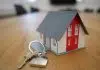 white and red wooden house miniature on brown table
